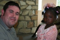 Ashley Cooper with his Compassion sponsor child Rose who is from Haiti - as of yet Ashley doesn't know if she has survived